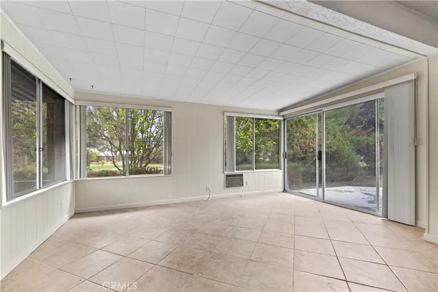a view of an empty room with windows and balcony