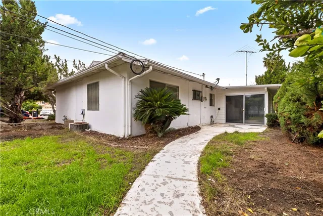 a front view of house with yard and trees around