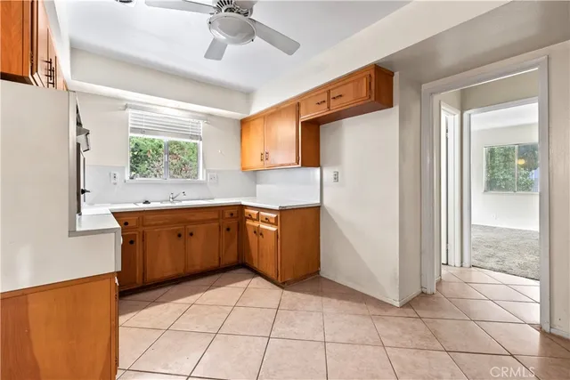 a kitchen with a sink a stove cabinets and wooden floor
