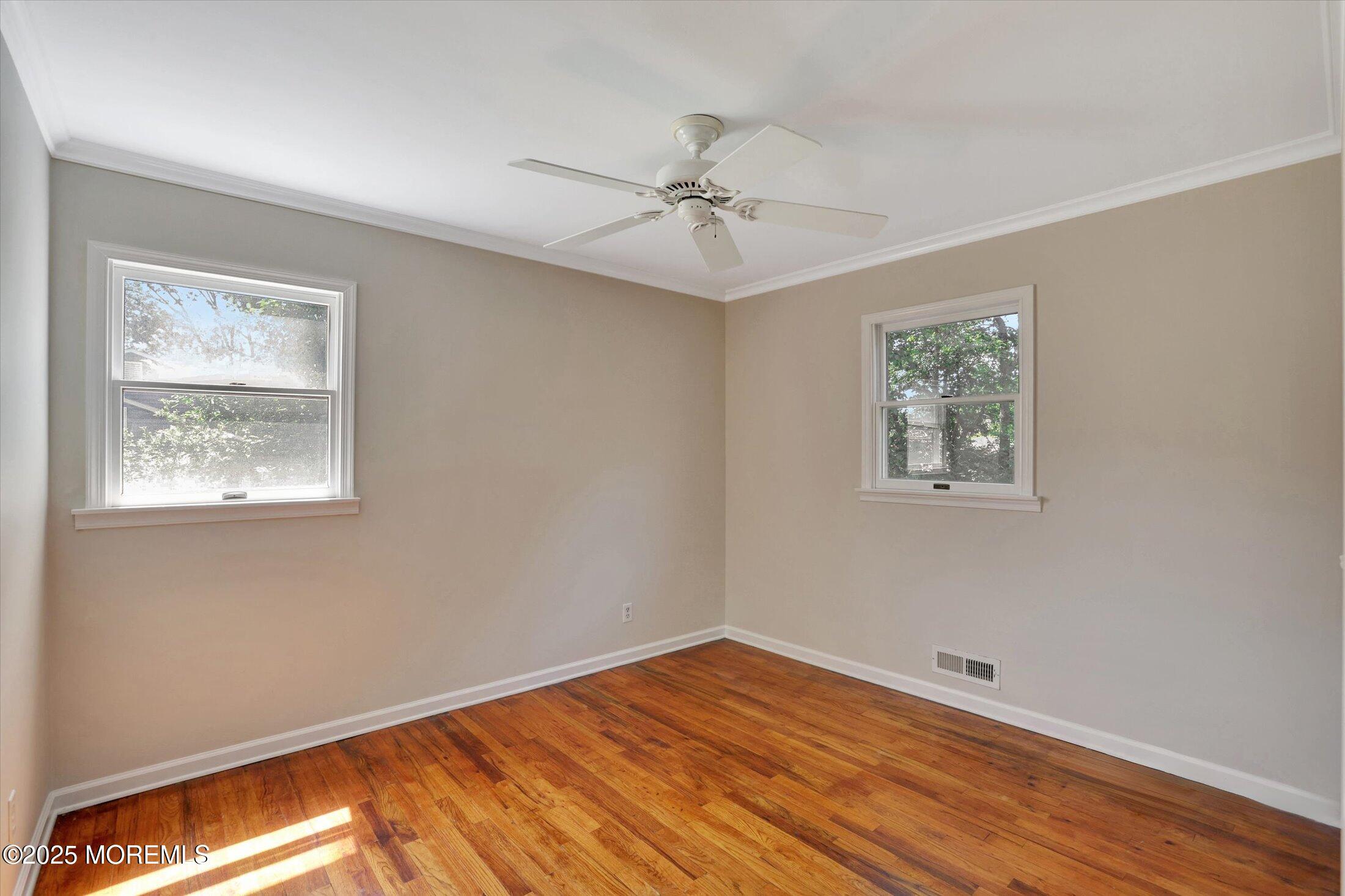 23 Princeton Drive Howell, NJ 07731 - Photo 11 of 32 a view of empty room with wooden floor and fan