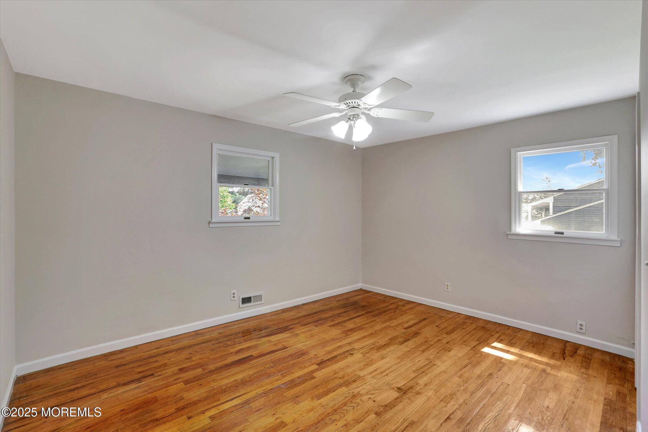 23 Princeton Drive Howell, NJ 07731 - Photo 10 of 32 a view of empty room with wooden floor and fan