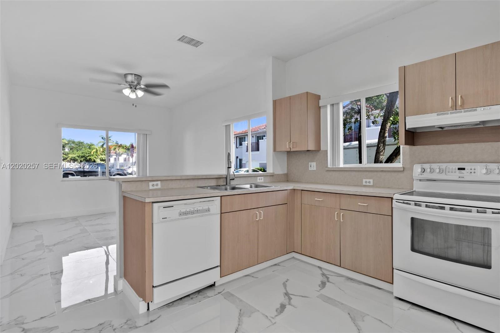 10245 Southwest 154th Place, Unit 1123 Miami, FL 33196 - Photo 16 of 38 a kitchen with a stove and white cabinets
