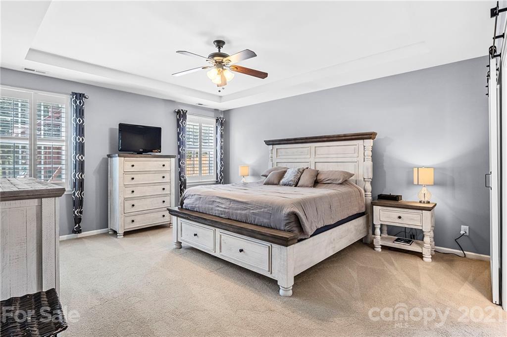 88 Roanoke Road Fletcher, NC 28732 - Photo 14 of 34 a spacious bedroom with a bed and a flat screen tv