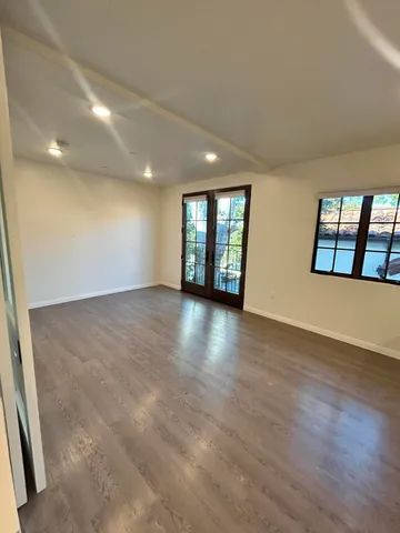 a kitchen with stainless steel appliances a sink dishwasher stove and white cabinets with wooden floor