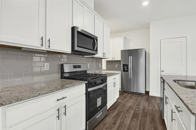 a view of a kitchen with a dishwasher and a stove top oven