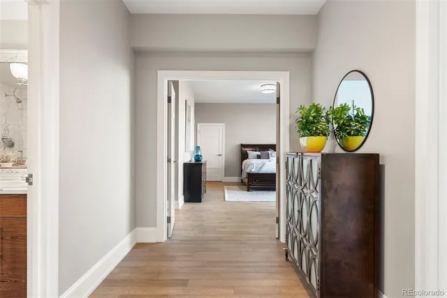 a view of a hallway with dining room and wooden floor