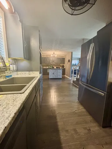 a kitchen with stainless steel appliances granite countertop a sink a stove and a refrigerator