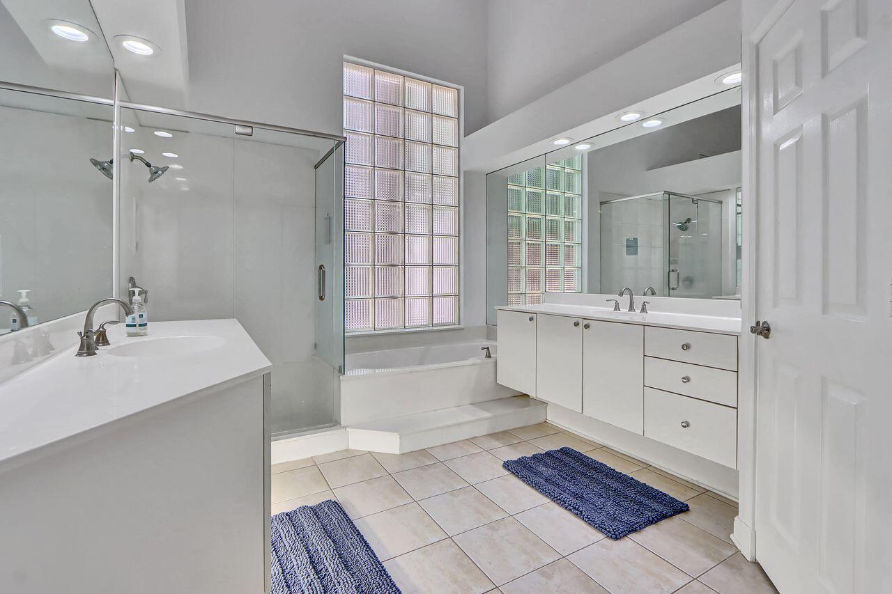 6631 Northwest 43rd Terrace Boca Raton, FL 33496 - Photo 12 of 36 a spacious bathroom with a double vanity sink a mirror and a bathtub