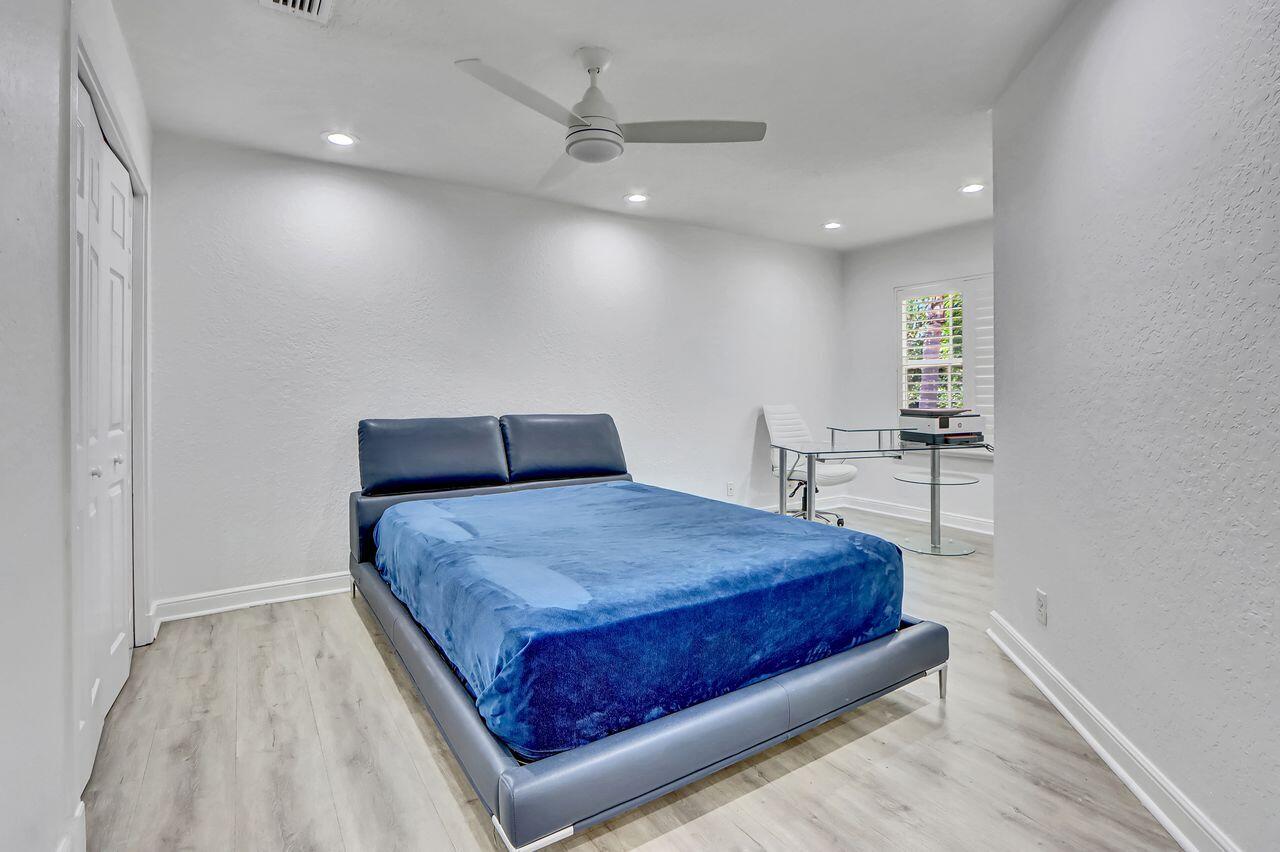 6631 Northwest 43rd Terrace Boca Raton, FL 33496 - Photo 16 of 36 a bedroom with a bed and a table
