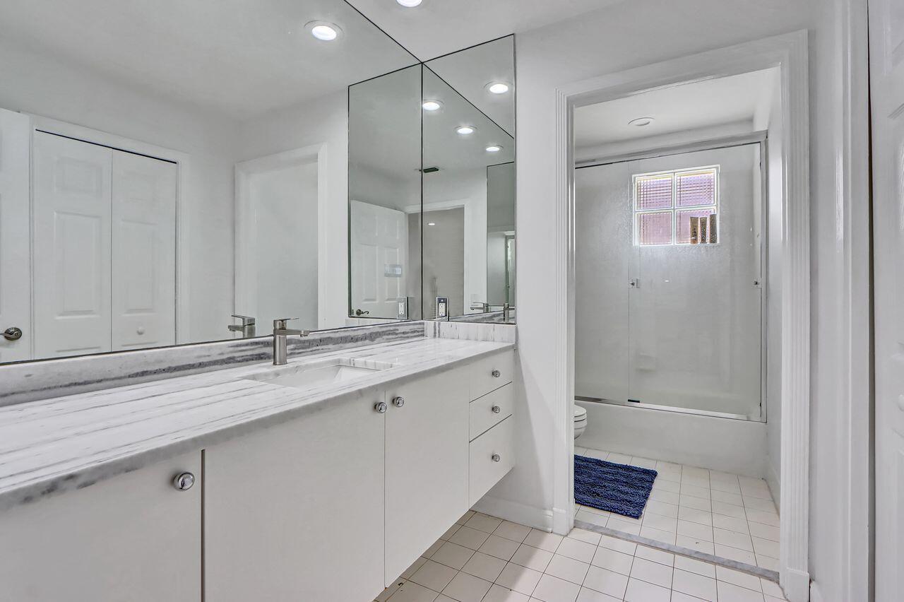 6631 Northwest 43rd Terrace Boca Raton, FL 33496 - Photo 17 of 36 a bathroom with a granite countertop sink a mirror and a bathtub