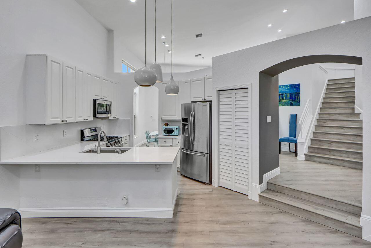 6631 Northwest 43rd Terrace Boca Raton, FL 33496 - Photo 8 of 36 a kitchen with stainless steel appliances granite countertop a sink a stove and a refrigerator