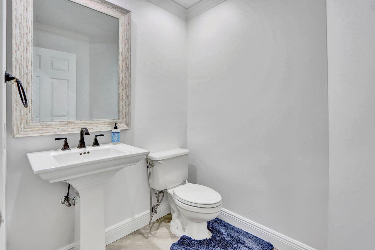 6631 Northwest 43rd Terrace Boca Raton, FL 33496 - Photo 10 of 36 a bathroom with a sink a toilet and mirror