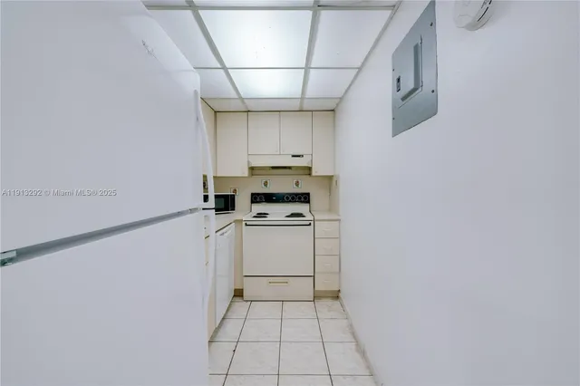 a kitchen with white cabinets and white appliances