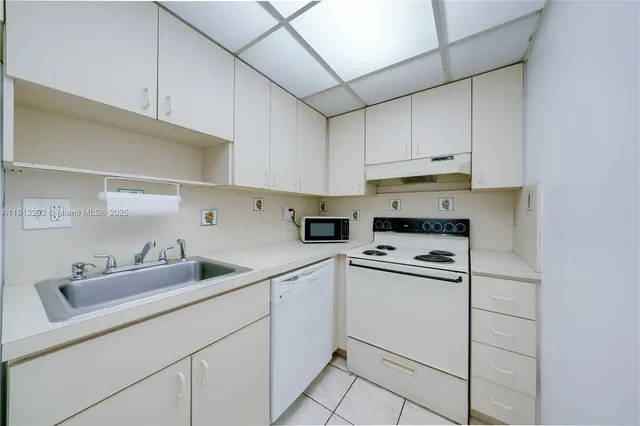 a kitchen with cabinets appliances a sink and a counter top