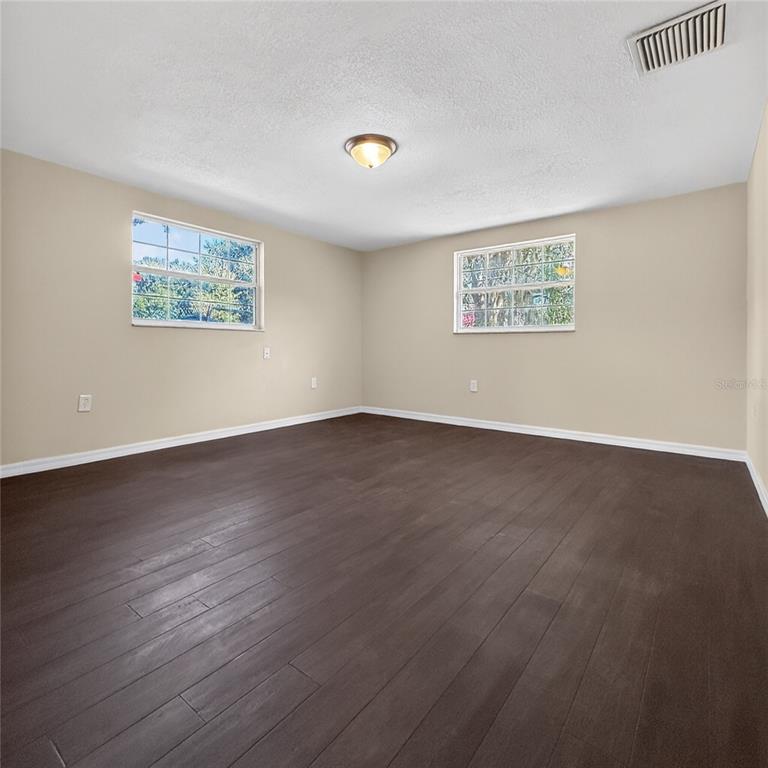 17220 Estes Road Lutz, FL 33548 - Photo 21 of 25 a view of an empty room with wooden floor and a window