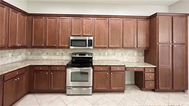 a kitchen with stainless steel appliances granite countertop a sink refrigerator and cabinets