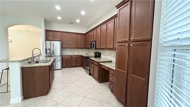 a kitchen with granite countertop wooden cabinets and stainless steel appliances