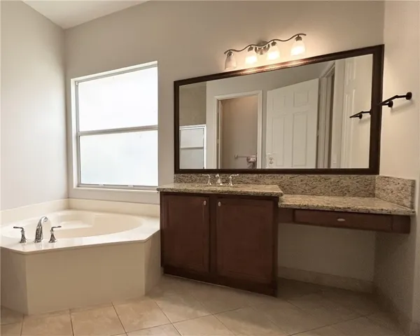 a bathroom with a granite countertop shower sink and mirror