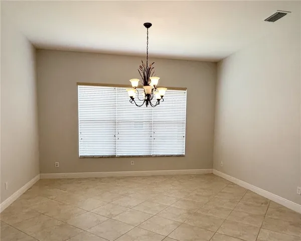 an empty room with wooden floor ceiling fan and window