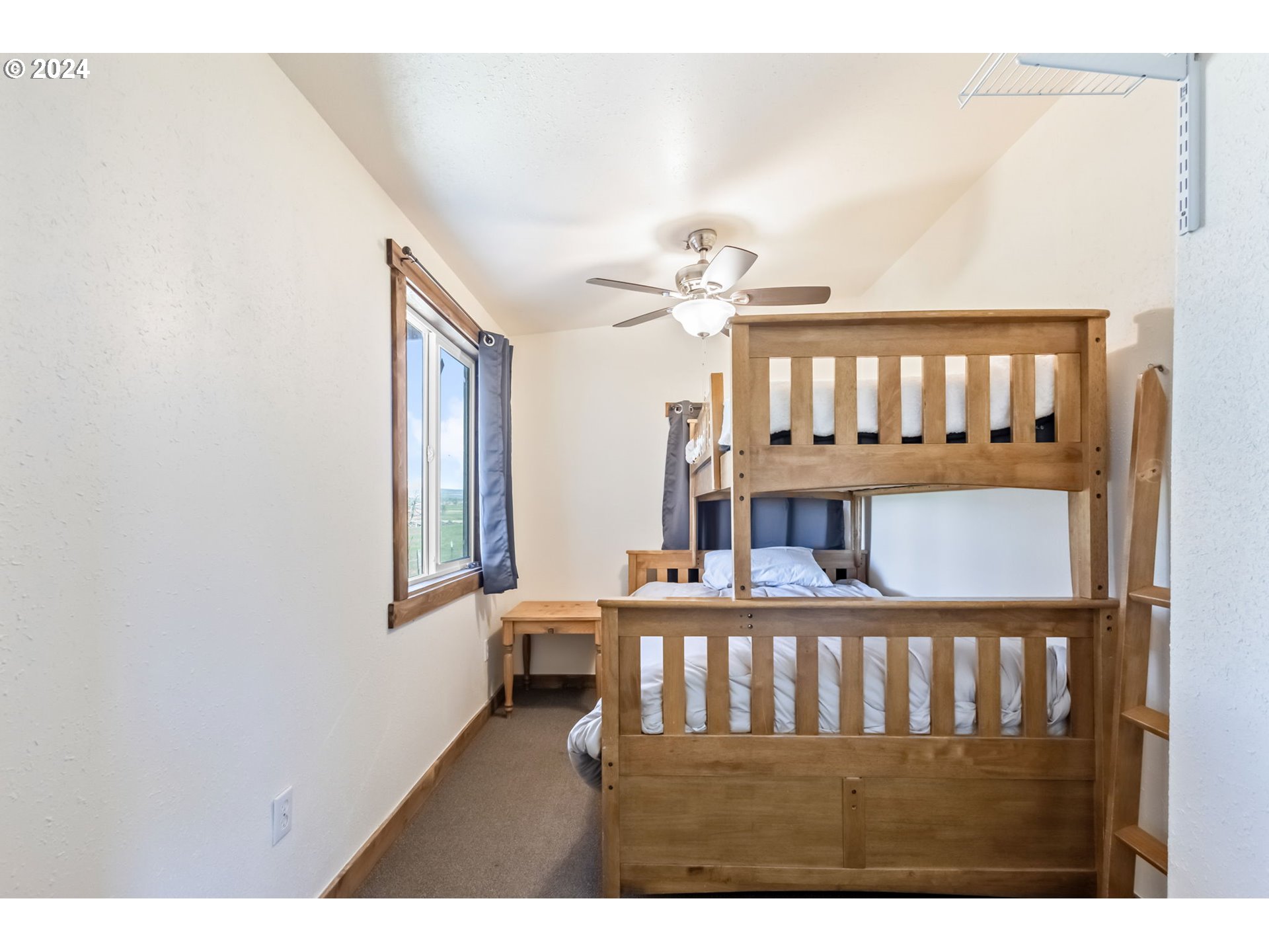3068 Southwest Reif Road Powell Butte, OR 97753 - Photo 32 of 42 a view of a bedroom with furniture and window