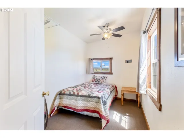 a bedroom with a bed chandelier and a window