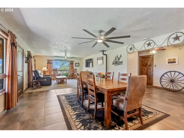 a view of a dining room and livingroom view with furniture wooden floor and a rug