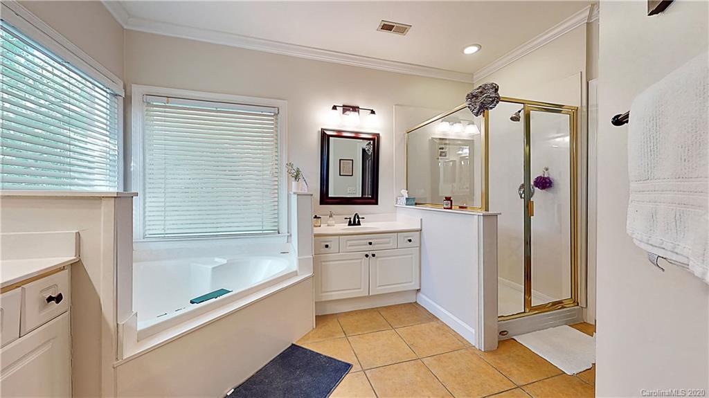 3234 Rhett Butler Place Charlotte, NC 28270 - Photo 13 of 27 a bathroom with a tub a sink a mirror and a shower