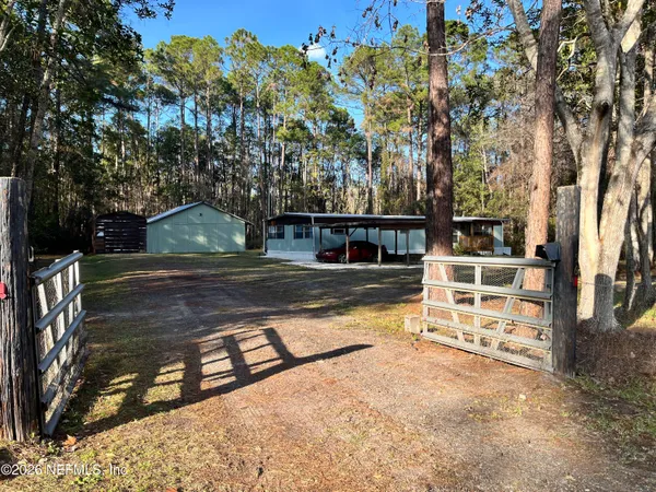 a view of a yard with wooden fence