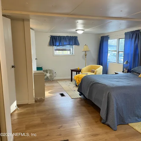 a bedroom with a bed and wooden floor