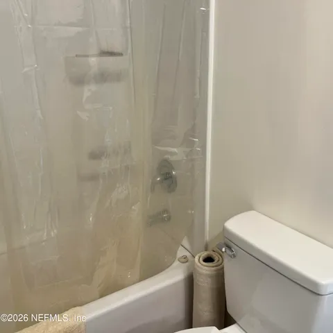 a white toilet sitting next to a bath tub