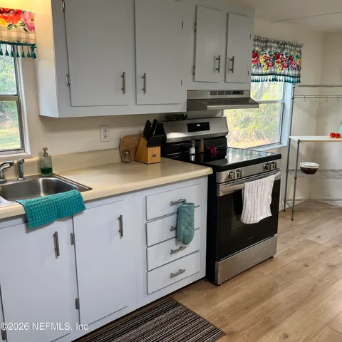 a kitchen with granite countertop a stove sink and cabinets