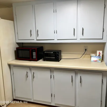 a kitchen with white cabinets and white appliances