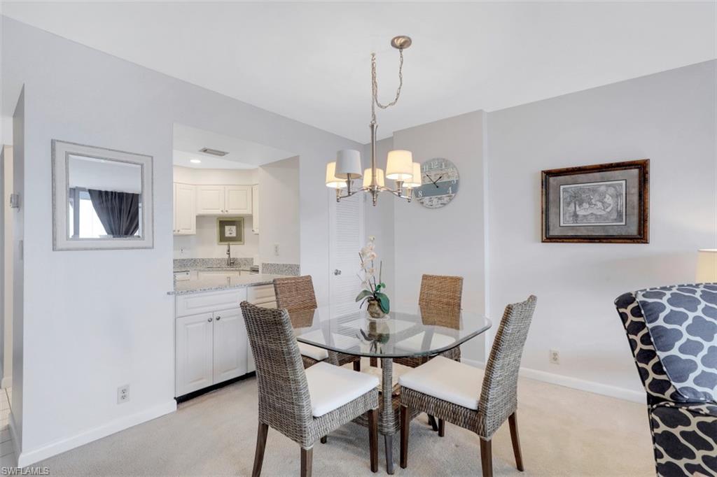 5 Bluebill Avenue, Unit 810 Naples, FL 34108 - Photo 7 of 19 a view of a dining room with furniture and chandelier