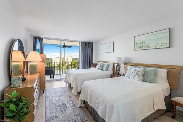 a spacious bedroom with two beds and a large window