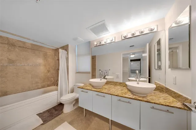 a bathroom with a granite countertop sink a toilet a mirror and shower