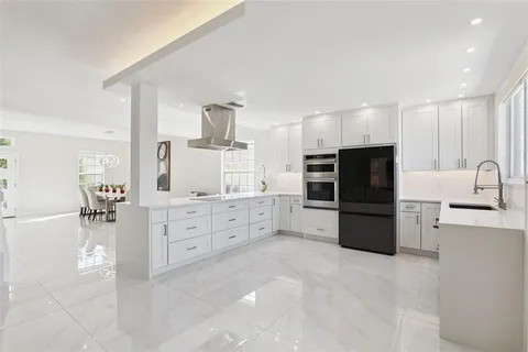 a kitchen with granite countertop a refrigerator and a stove top oven