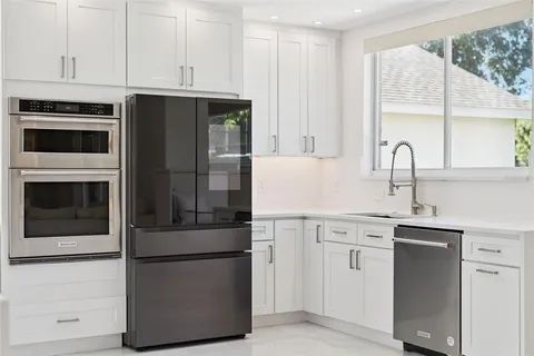 a kitchen with appliances a sink and cabinets