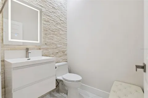 a bathroom with a toilet sink vanity and mirror