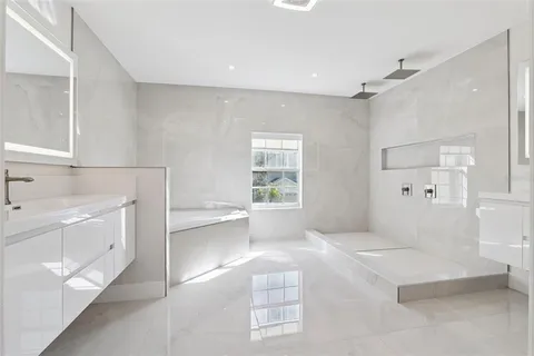 a spacious bathroom with a bathtub sink and mirror