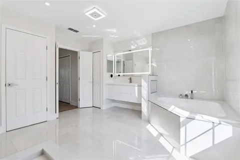 a bathroom with a tub sink and mirror