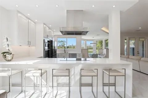 a kitchen with stainless steel appliances kitchen island granite countertop a table and chairs in it