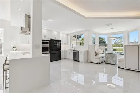 a kitchen with stainless steel appliances kitchen island granite countertop a refrigerator and cabinets