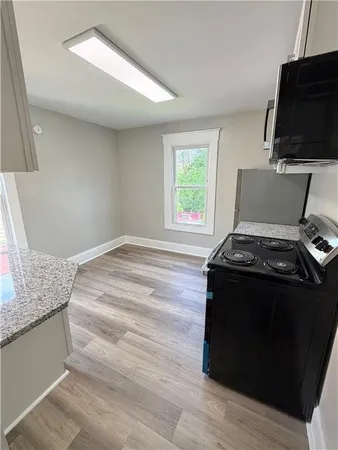 a living room with a stove and a wooden floor