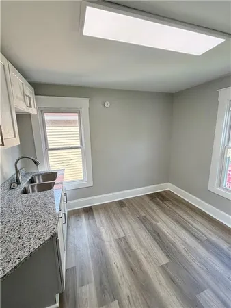 a kitchen with granite countertop wooden floors and wide window