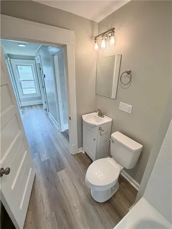 a white toilet sitting next to a bathroom sink and a mirror