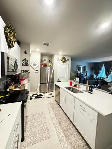 a kitchen with a refrigerator and a stove top oven