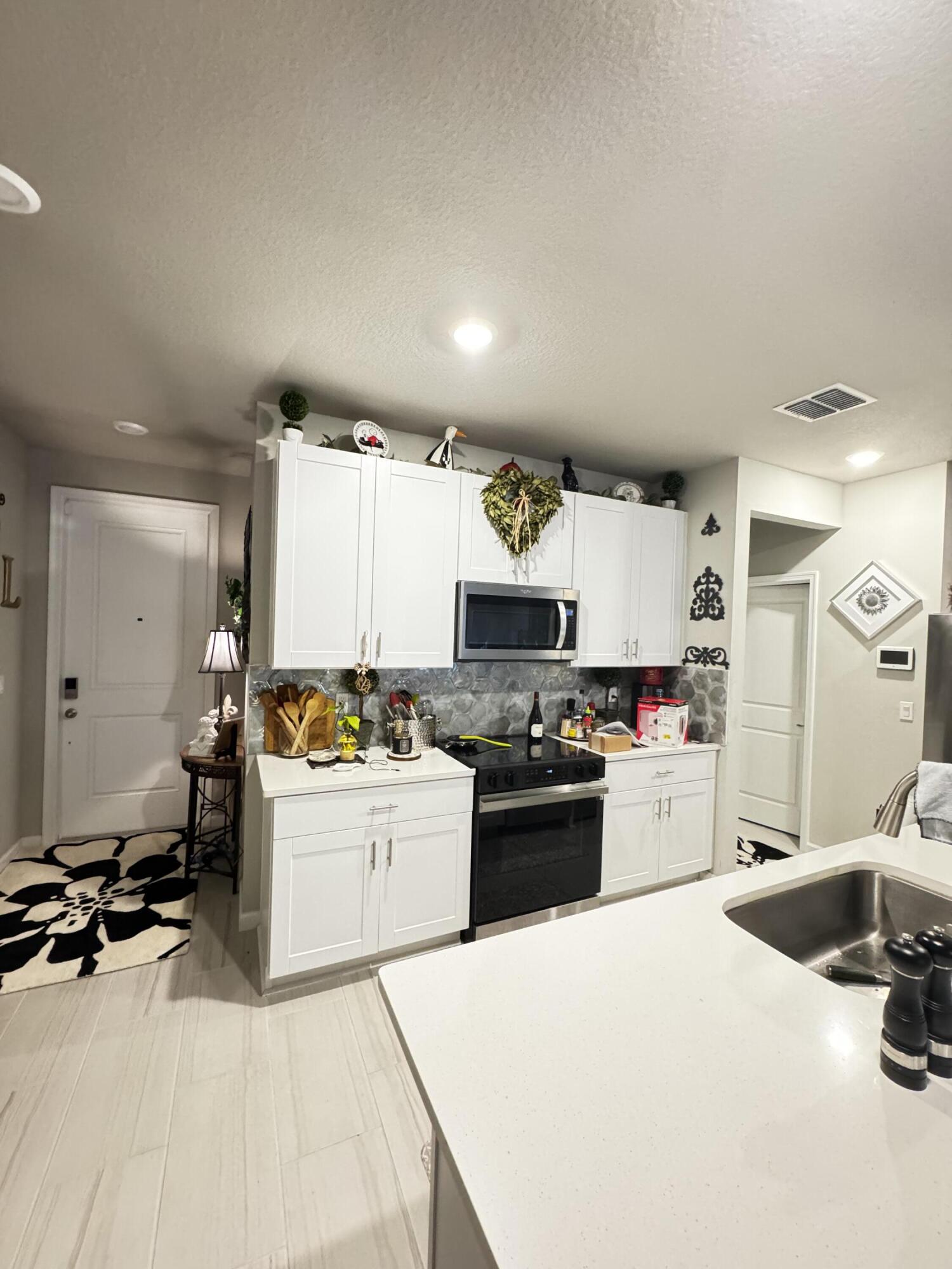5646 Southeast Edgewater Circle Stuart, FL 34997 - Photo 5 of 20 a kitchen with a refrigerator and a stove top oven