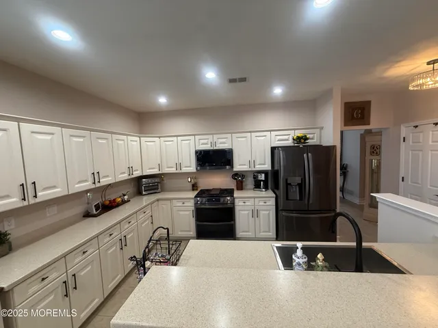 a kitchen with refrigerator and cabinets