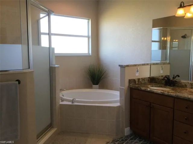 a bathroom with a granite countertop sink a toilet and mirror