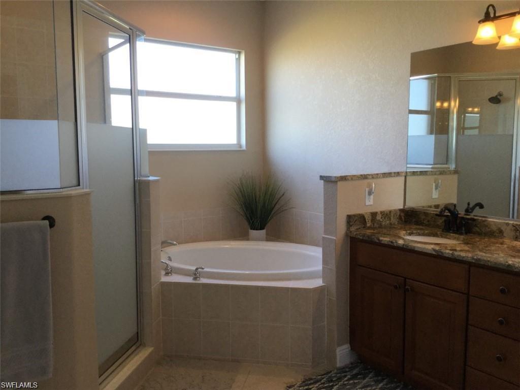 20085 Larino Loop Estero, FL 33928 - Photo 15 of 18 a bathroom with a granite countertop sink a toilet and mirror